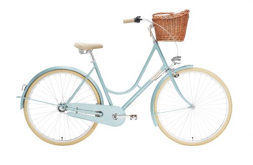 Creme HolyMoly Solo ladies road bike in jade blue colour. Retro-looking bike made by Creme. Featuring front wicker basket, comfy cream coloured saddle, cream tyres, hub-enclosed chain, and front headlamp. Side on view of the bike.  