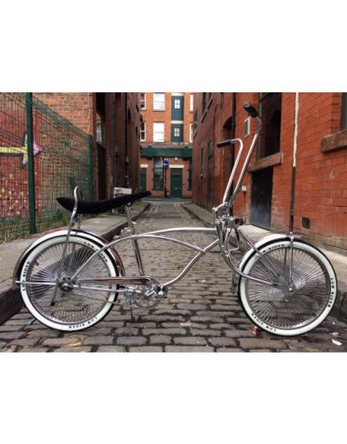 Classic chrome lowrider bike, lifestyle photo, side view, stood up on the cobbled brick street.